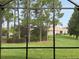 Backyard view from screened lanai offers lush green grass and mature tree landscaping at 2495 Palm Tree Dr, Kissimmee, FL 34759
