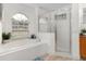 Light bathroom features a soaking tub, glass shower, and window at 252 Barbera Dr, Davenport, FL 33897