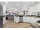 Open-concept kitchen with white cabinets, stainless steel appliances, and a seamless flow into the living room area at 252 Barbera Dr, Davenport, FL 33897