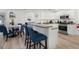 Modern kitchen featuring white cabinets, stainless steel appliances, and a breakfast bar connecting to the dining area at 252 Barbera Dr, Davenport, FL 33897