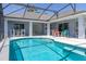 Sparkling screened-in pool with lounge chairs and dining table at 252 Barbera Dr, Davenport, FL 33897