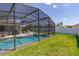 Screened-in pool with a well-manicured lawn and lounge chairs at 252 Barbera Dr, Davenport, FL 33897
