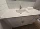 Bathroom vanity with white shaker cabinets, chrome hardware, white countertop and white subway tile backsplash at 2572 Robert Trent Jones Dr # 1227, Orlando, FL 32835