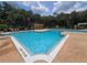 Community swimming pool surrounded by lounge chairs and palm trees at 2572 Robert Trent Jones Dr # 1227, Orlando, FL 32835