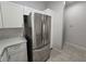Stainless steel refrigerator in a modern kitchen with white cabinets and tiled backsplash at 2572 Robert Trent Jones Dr # 1227, Orlando, FL 32835
