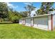 Lush backyard features multiple garages, providing ample storage and parking space for vehicles and equipment at 2740 Barker Rd, St Cloud, FL 34771
