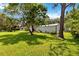 Expansive backyard features lush lawn, mature trees, and multiple outbuildings, offering space and utility at 2740 Barker Rd, St Cloud, FL 34771