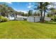 Expansive backyard features lush lawn, mature trees, and multiple outbuildings, offering space and utility at 2740 Barker Rd, St Cloud, FL 34771
