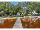 Wooden dock leading to waterfront homes with mature trees at 2740 Barker Rd, St Cloud, FL 34771
