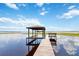 Dock with a boat house featuring seating area on a serene lake with reflections of the sky at 2740 Barker Rd, St Cloud, FL 34771