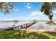 Waterfront property featuring long wooden dock leading to boat house in a beautiful lake setting at 2740 Barker Rd, St Cloud, FL 34771