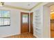Foyer with a decorative glass front door, wood-look flooring, and built-in shelving at 2740 Barker Rd, St Cloud, FL 34771