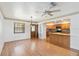 Bright and airy living room with hardwood floors, a ceiling fan, and a partial view into the kitchen at 2740 Barker Rd, St Cloud, FL 34771