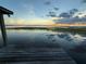 Relaxing view overlooking the lake from the dock with a stunning sunset and sky reflected in the still water at 2740 Barker Rd, St Cloud, FL 34771