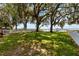 Scenic yard features mature trees, lush greenery, a white picket fence, and views of the water at 2740 Barker Rd, St Cloud, FL 34771
