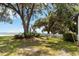 Scenic yard features mature trees, lush greenery, a white picket fence, and views of the water at 2740 Barker Rd, St Cloud, FL 34771