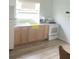 Bright kitchen featuring white appliances, wood-look floors, and light wood cabinets at 380 S Echo Dr, Lake Alfred, FL 33850