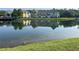 Beautiful pond view reflecting colorful townhomes and mature trees against a clear sky at 4008 San Gallo Dr # 106, Kissimmee, FL 34741
