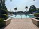Inviting community pool area featuring clear water, palm trees, and comfortable lounge chairs at 4008 San Gallo Dr # 106, Kissimmee, FL 34741