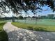 Exterior view of fenced tennis courts with green surfaces and a walkway at 4008 San Gallo Dr # 106, Kissimmee, FL 34741
