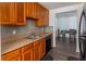 A bright kitchen features a stainless sink, black dishwasher, wood cabinets and a tiled backsplash at 4017 Dijon Dr # 4017K, Orlando, FL 32808