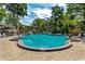 Large community pool surrounded by lush greenery and lounge chairs at 4017 Dijon Dr # 4017K, Orlando, FL 32808