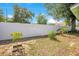 The property line has a white fence with growing plant life with plenty of open space for landscaping at 416 E Seminole Ave, Lake Wales, FL 33853