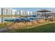 Canoes on a rack next to the lake with the apartment building and dock in the background at 4875 Clock Tower Dr, Kissimmee, FL 34746