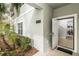 Inviting front entrance with open door, manicured landscape, and view to entry way at 4875 Clock Tower Dr, Kissimmee, FL 34746