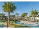 Scenic lazy river with a tiki hut, palm trees, and tropical landscaping throughout the community at 4875 Clock Tower Dr, Kissimmee, FL 34746