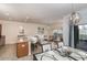 Spacious living area boasts a kitchen island, dining table, modern decor, and sliding glass door to screened patio at 4875 Clock Tower Dr, Kissimmee, FL 34746