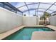 Tranquil screened-in pool area with a private backyard view and lounge chair at 4875 Clock Tower Dr, Kissimmee, FL 34746