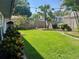 Lush backyard with a manicured lawn, bordered by trees and shrubs, offering a private outdoor retreat at 4926 Reginald Rd, Orlando, FL 32829