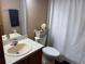 Standard bathroom with a single sink vanity, toilet with basket, and shower with white shower curtain at 4926 Reginald Rd, Orlando, FL 32829
