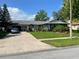 Well-maintained single-story home with a large driveway and beautifully landscaped front yard at 4926 Reginald Rd, Orlando, FL 32829