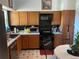 Functional kitchen with wood cabinets, black appliances, and black tile backsplash, providing a practical cooking space at 4926 Reginald Rd, Orlando, FL 32829
