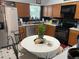 Functional kitchen features stainless steel appliances, wood cabinets, and a cozy breakfast table, ideal for casual dining at 4926 Reginald Rd, Orlando, FL 32829