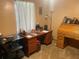 Spacious office featuring a large wooden desk, ample storage, and natural light from the large window at 4926 Reginald Rd, Orlando, FL 32829