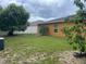 A spacious backyard featuring a well-maintained lawn and perimeter fence for privacy, and mature trees at 513 Ronshelle Ave, Haines City, FL 33844