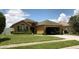 Well-manicured lawn, shrubbery, and a two-car garage enhance the appeal of this single-story home's exterior at 513 Ronshelle Ave, Haines City, FL 33844