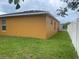Side yard with a white fence and part of the exterior showcasing the windows and grass at 513 Ronshelle Ave, Haines City, FL 33844
