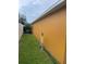 Side yard showing grass and the side of the home along with a white fence in the background at 513 Ronshelle Ave, Haines City, FL 33844
