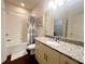 Bathroom featuring a shower over the tub, granite vanity, updated fixtures and vinyl floor at 5356 Diplomat Ct # 108, Kissimmee, FL 34746
