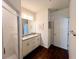 Bathroom featuring a double vanity, framed art, a walk-in shower with tiled surround, and dark wood floors at 5356 Diplomat Ct # 108, Kissimmee, FL 34746