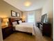 This cozy bedroom features a queen bed, two nightstands, a study desk, and an entertainment center with a TV at 5356 Diplomat Ct # 108, Kissimmee, FL 34746