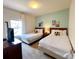 Bedroom with two twin beds, a window with white drapes, an entertainment center, and decorated with themed artwork at 5356 Diplomat Ct # 108, Kissimmee, FL 34746