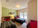 Bedroom with two beds, wall art, a window with curtains, and a small pool table at 5356 Diplomat Ct # 108, Kissimmee, FL 34746