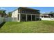 Expansive backyard with lush green grass and a two-story home featuring a screened-in porch at 5704 Ansley Way, Mount Dora, FL 32757