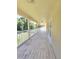 Covered back balcony or porch with views of the yard, mature trees, and landscaping at 5704 Ansley Way, Mount Dora, FL 32757