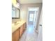 Cozy bathroom featuring wood cabinets, neutral countertops, and tile flooring at 5704 Ansley Way, Mount Dora, FL 32757